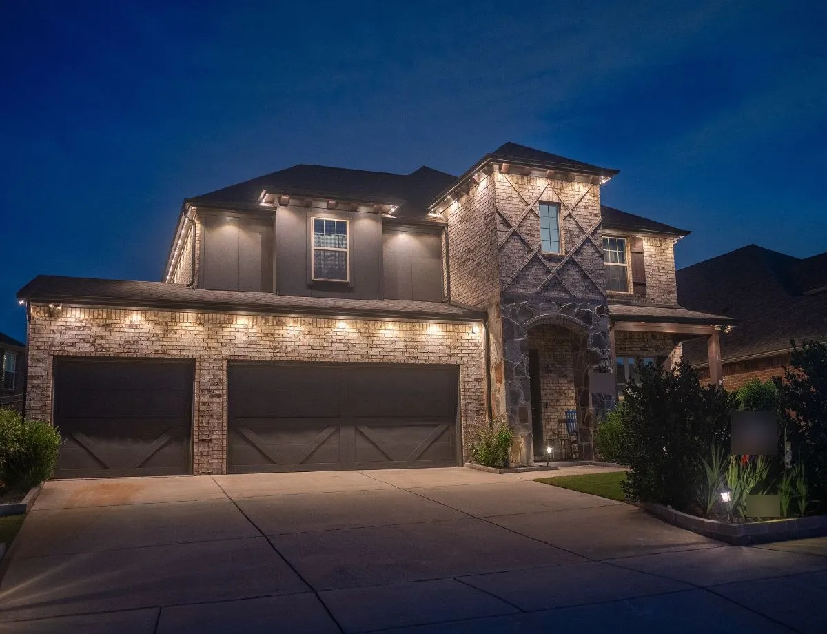 Two-story home with warm white lighting along the eaves and garage