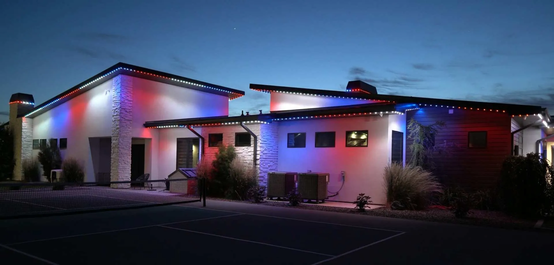 Home with red, white and blue gameday lighting along the roofline