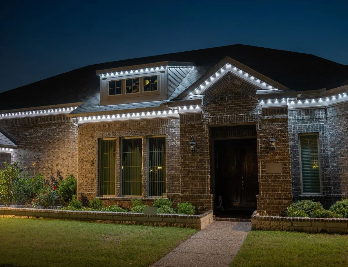 Brick home with bright white lights along the roofline