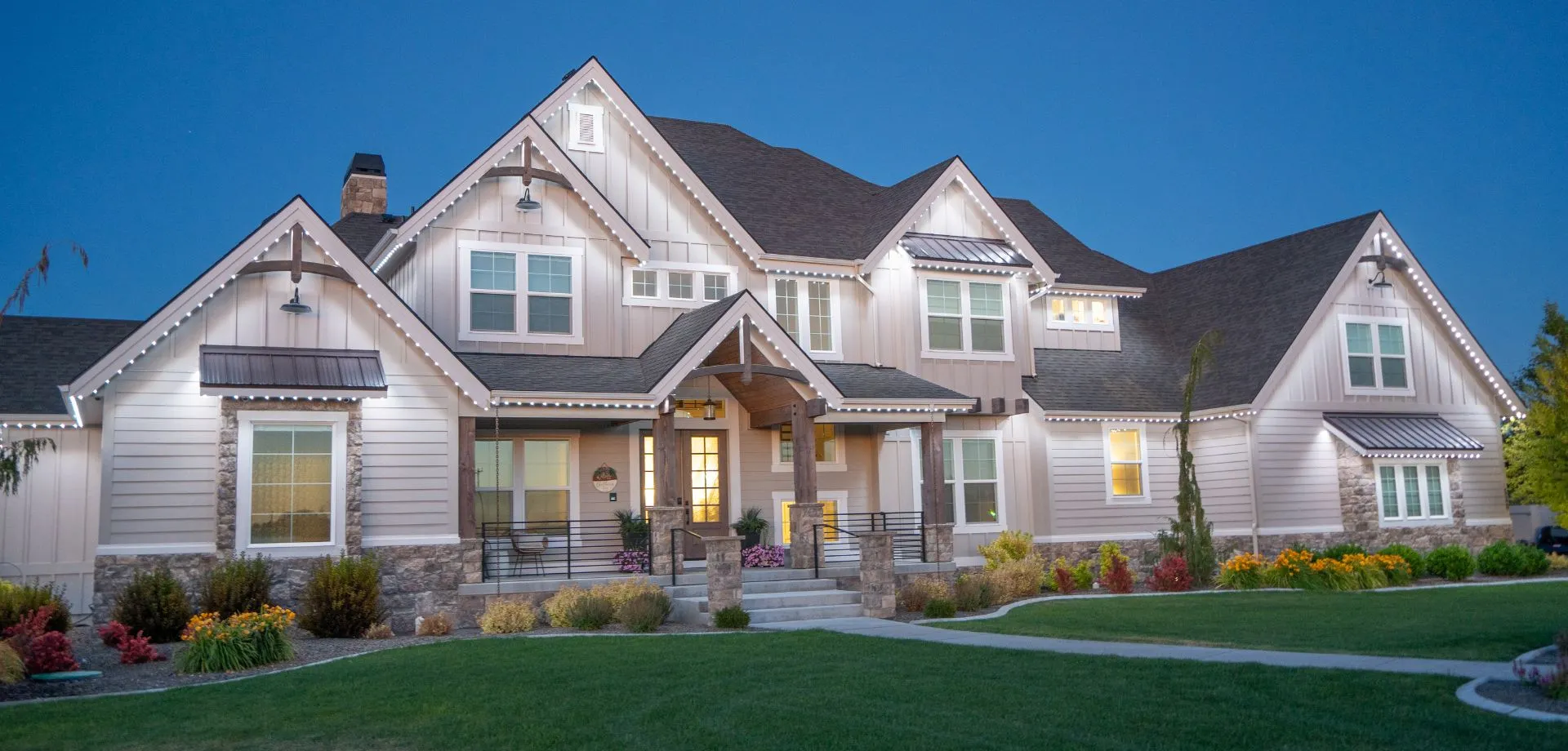 Two-story home with bright white roofline lighting at dusk